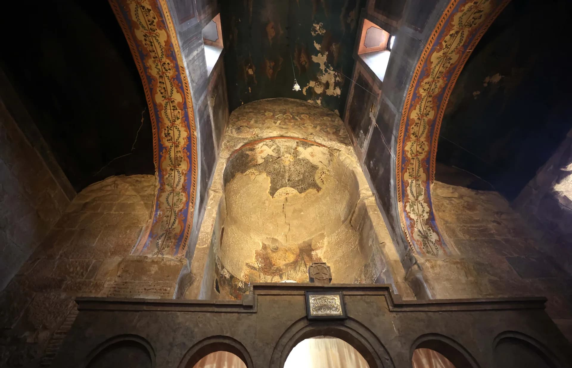 17th - century wall-painting layer, executed in 1683 on the commission of Catholicos Nikoloz Amilakhvari. This layer includes the partially preserved figures of the Eucharist scene on both sides of the upper part of the apse window, as well as the lower fragment of the figure of the enthroned Virgin Mary above the window. The front of the conch is entirely covered by a complex, multi-figured composition of the Tree of Jesse.